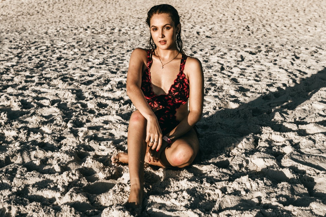 sitting on the beach wearing a necklace
