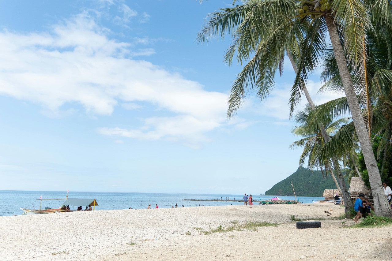 A sunny day at Lanikai Beach in O’ahu, Hawaii with people enjoying the weather.