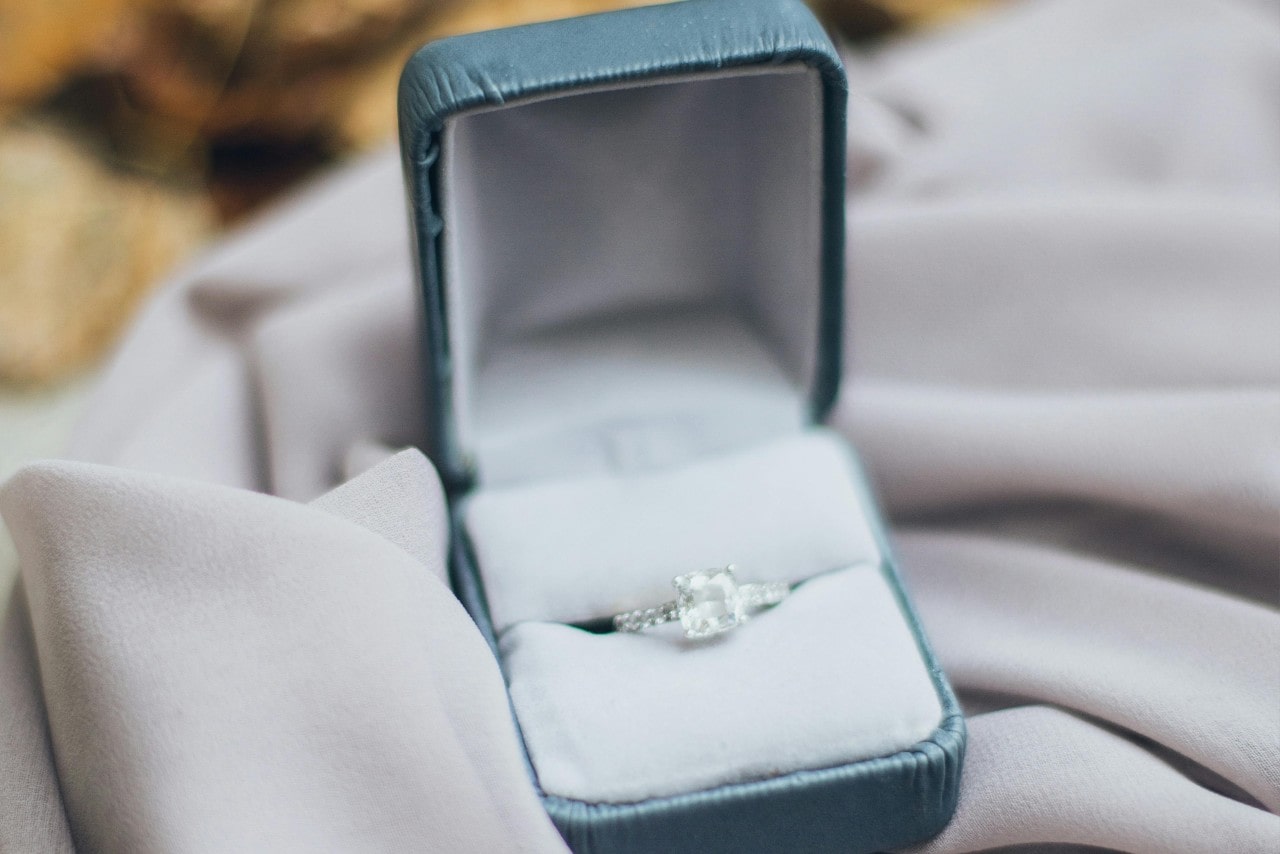 a princess cut diamond ring in a blue ring box