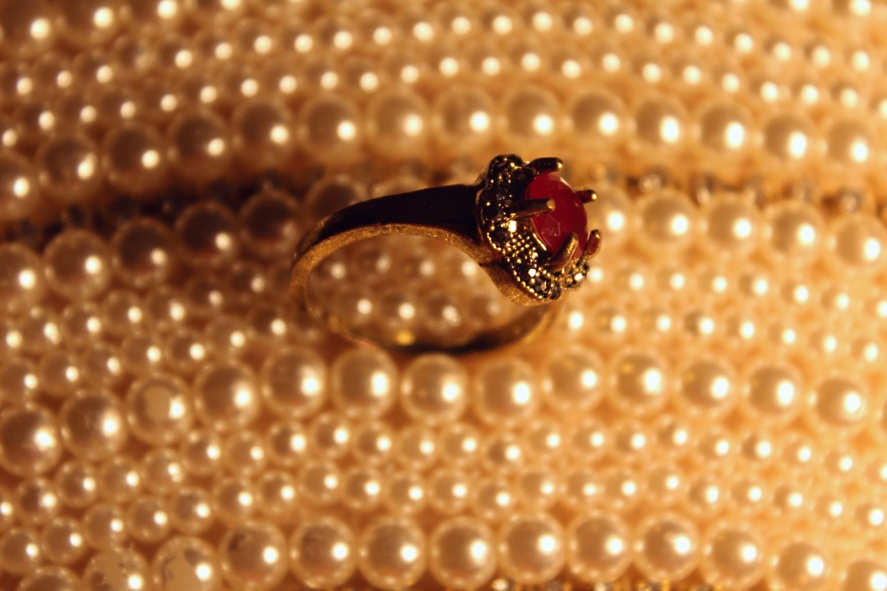 a ruby ring situated atop strings of pearls a ruby ring situated atop strings of pearls