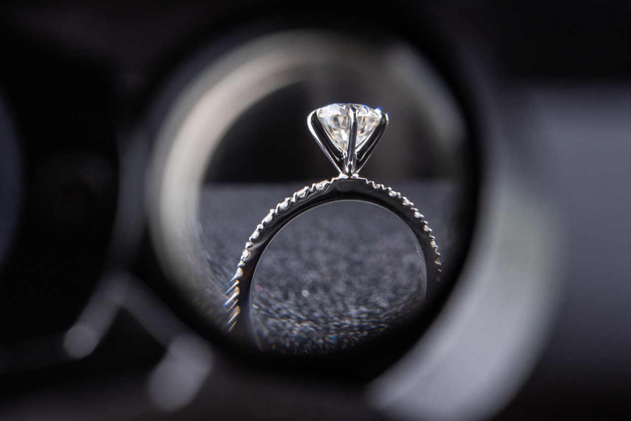 A view through a jeweler’s magnifying glass of a ring’s side profile. A view through a jeweler’s magnifying glass of a ring’s side profile.