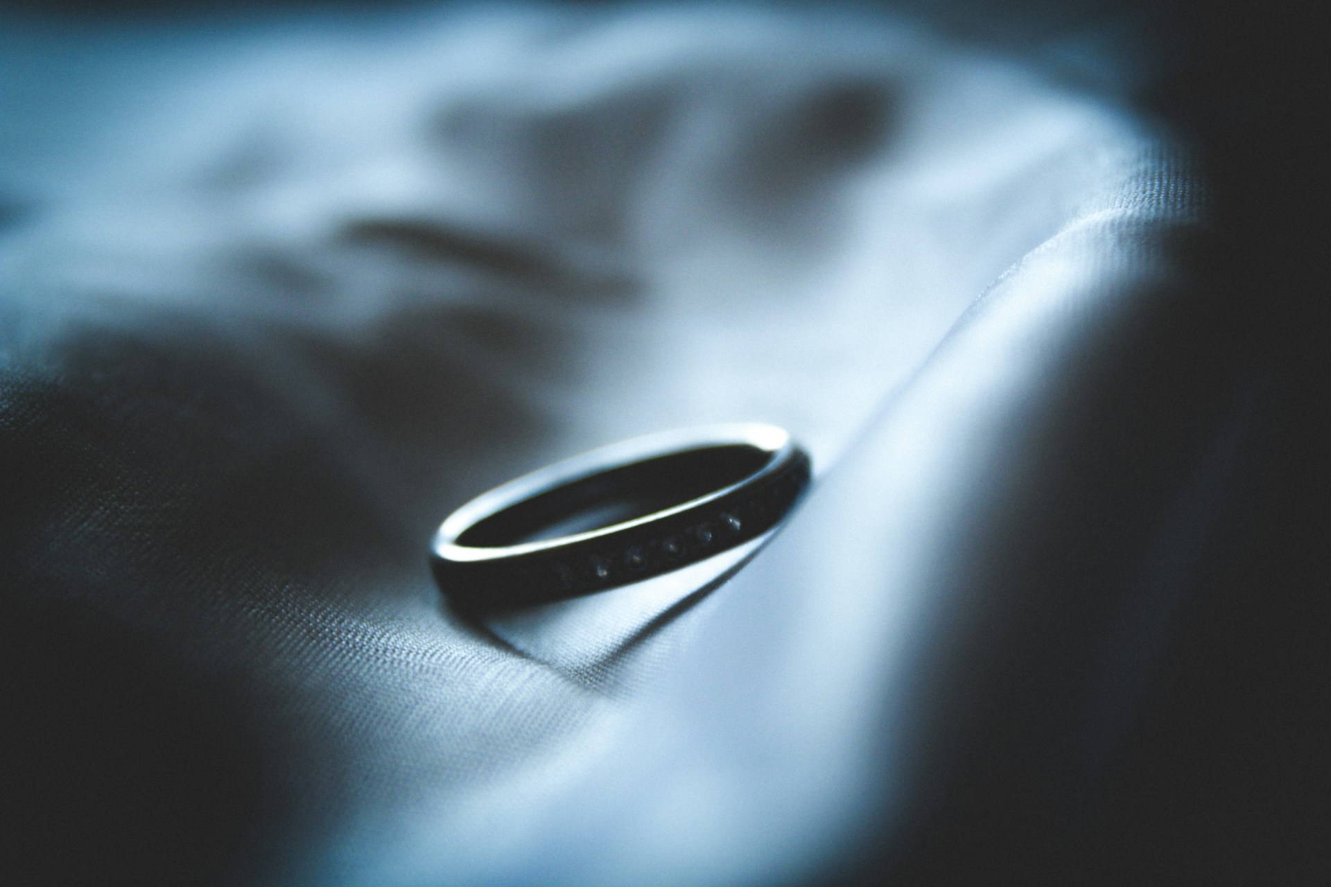 a black wedding band on a light surface a black wedding band on a light surface
